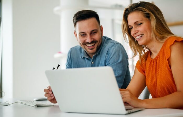 two coworkers using a tool for better document management in the office using a laptop