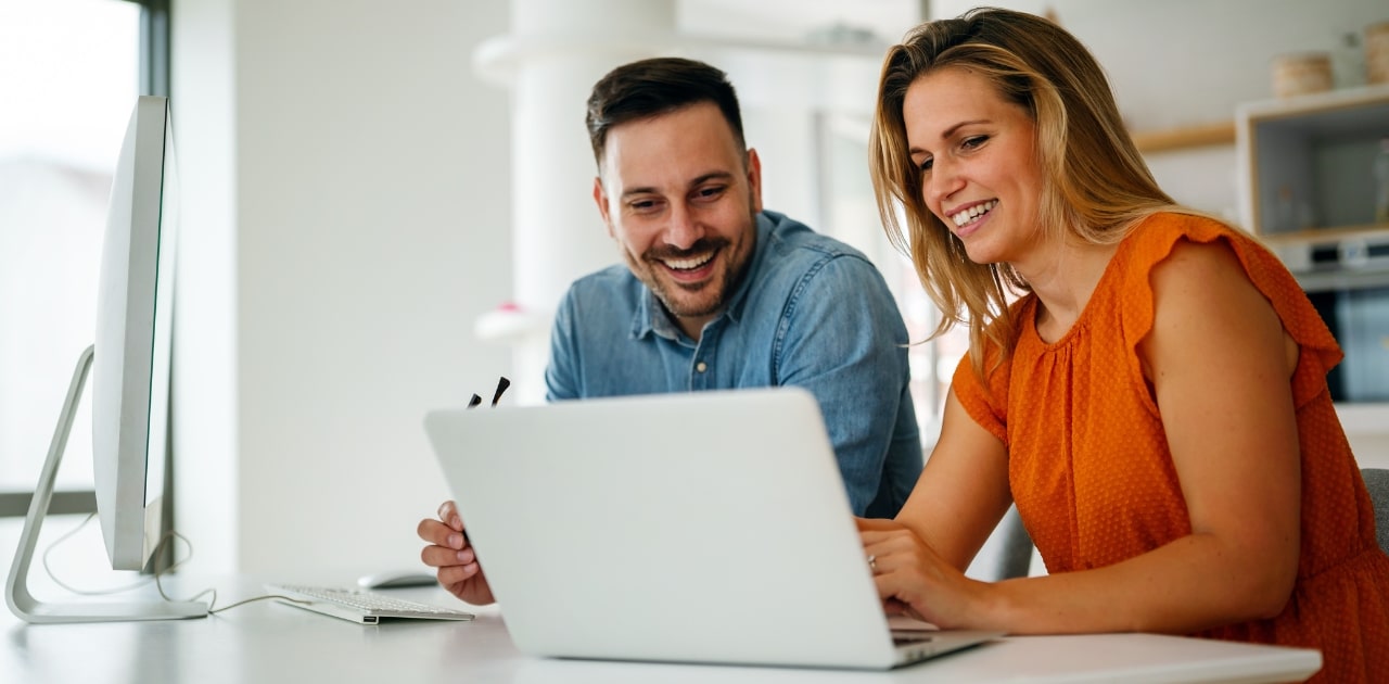 two coworkers using a tool for better document management in the office using a laptop