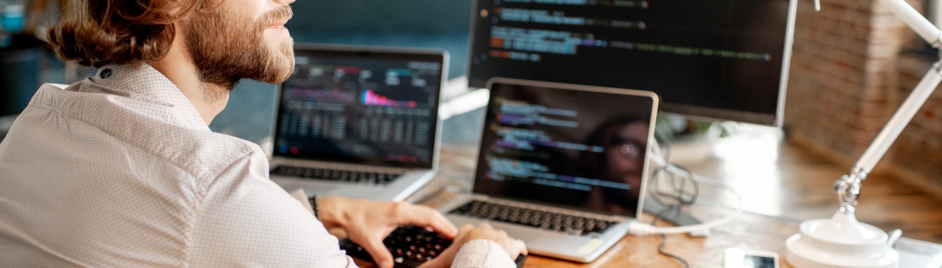handsome man putting code into multiple devices