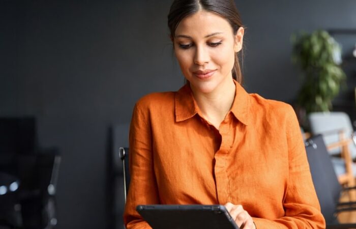 business woman standing in modern office using a tablet