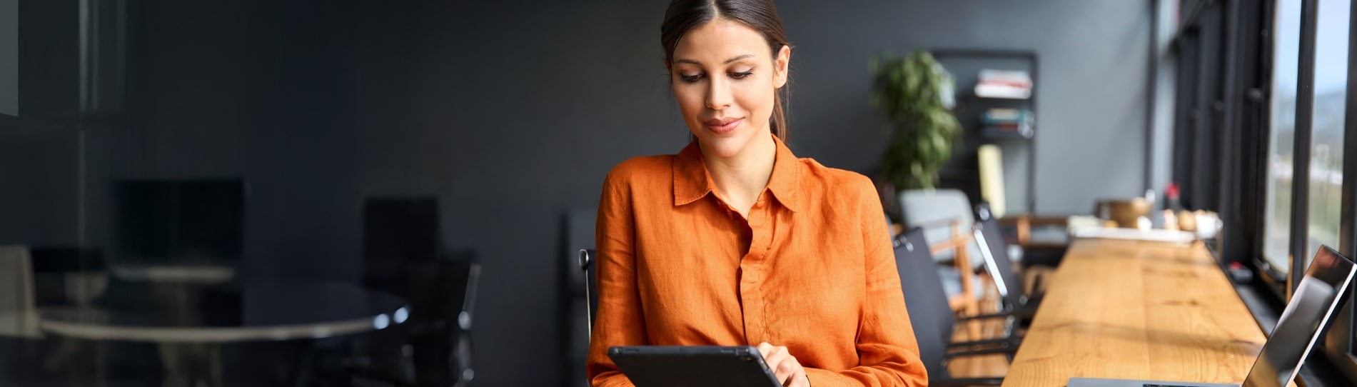 business woman standing in modern office using a tablet